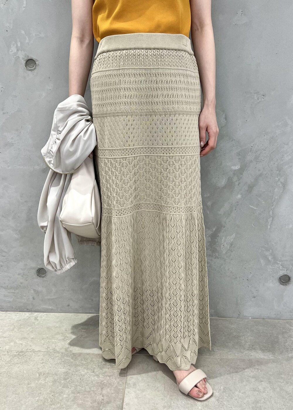 ベージュ系のサンダル、ベージュ系のブルゾン、オレンジ系のニット/セーターを着用したレディースの春コーディネートの6枚目の写真