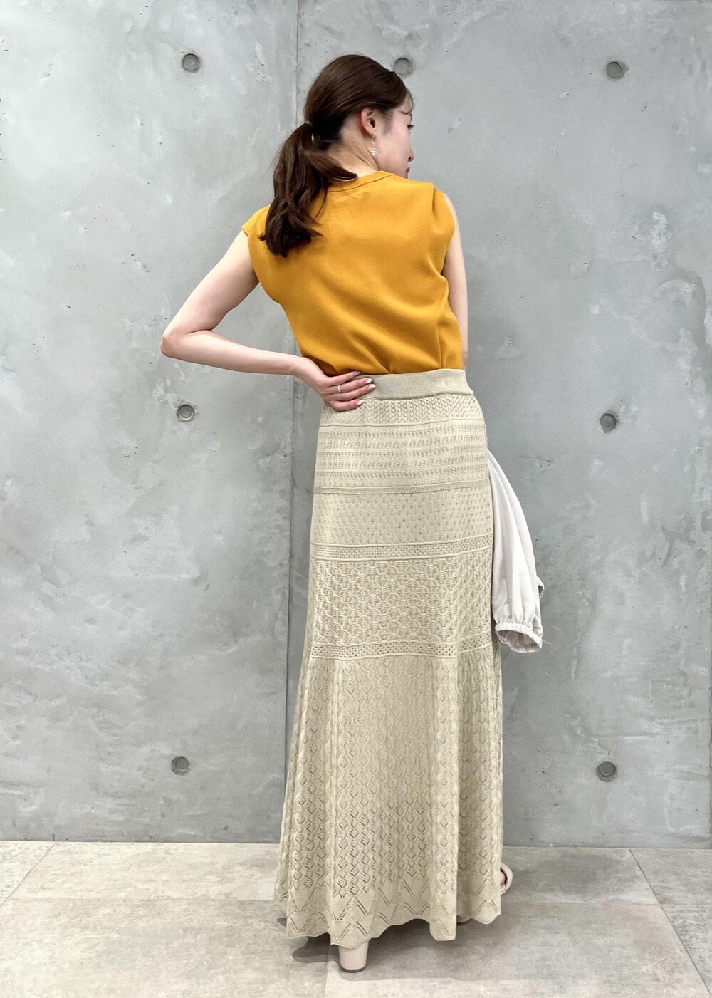 ベージュ系のサンダル、ベージュ系のブルゾン、オレンジ系のニット/セーターを着用したレディースの春コーディネートの5枚目の写真