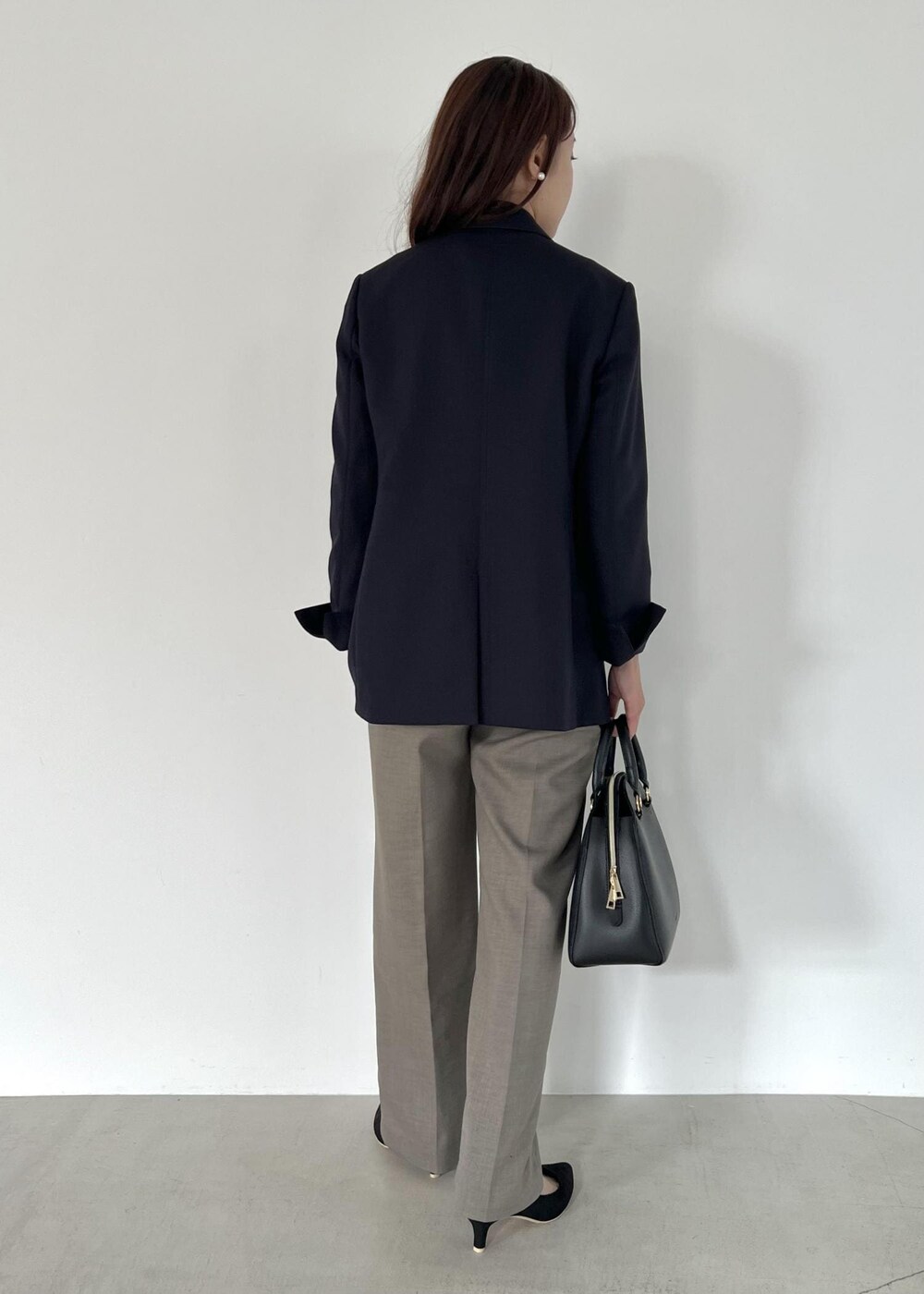 ブラック系のボストンバッグ、ブルー系のテーラードジャケット、ホワイト系のニット/セーターを着用したレディースの秋コーディネートの3枚目の写真