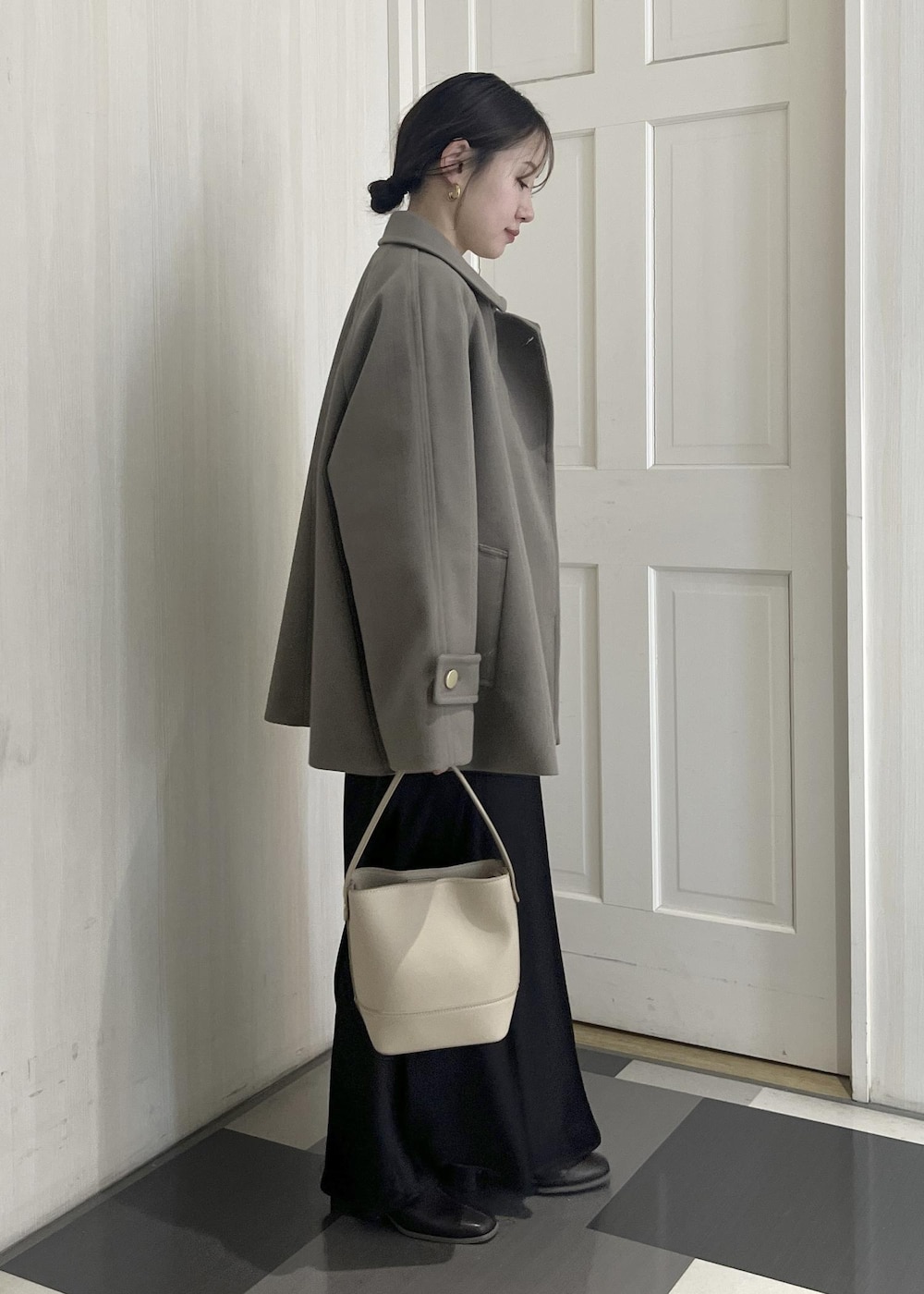 ホワイト系のニット/セーター、ブラウン系のその他アウター、ベージュ系のショルダーバッグを着用したレディースの冬コーディネートの6枚目の写真