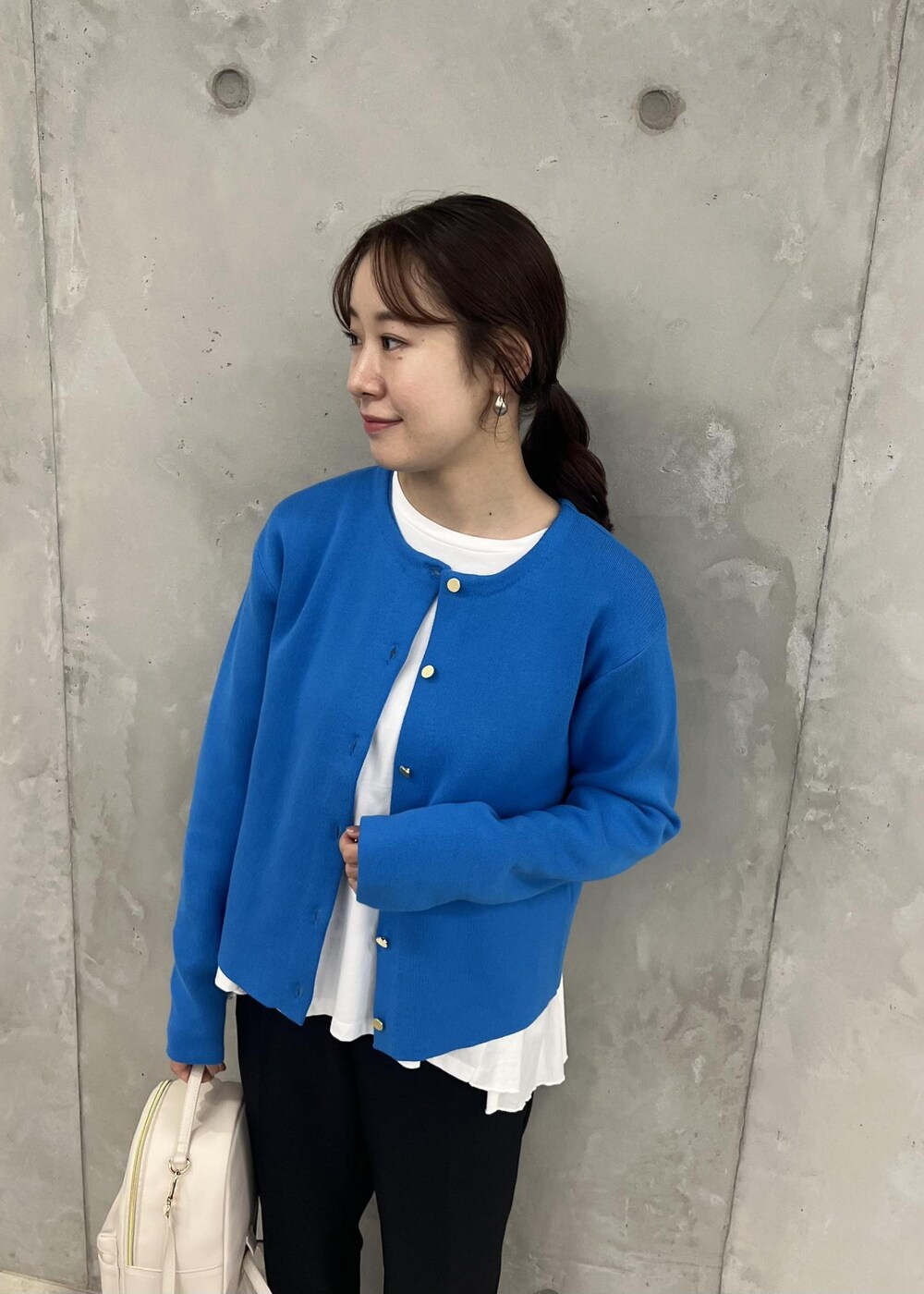 ブラック系のその他パンツ、ホワイト系のバックパック/リュック、ブルー系のカーディガン/ボレロを着用したレディースの秋コーディネートの4枚目の写真