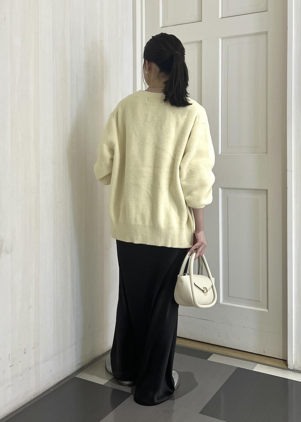 ホワイト系のショルダーバッグ、シルバー系のスニーカー、ベージュ系のカーディガン/ボレロを着用したレディースの冬コーディネートの4枚目の写真