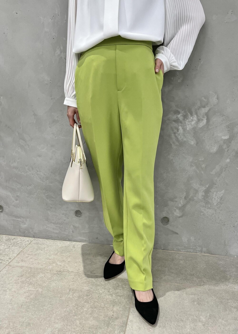 ホワイト系のシャツ/ブラウス、ホワイト系のショルダーバッグ、グリーン系のスラックスを着用したレディースの春コーディネートの6枚目の写真