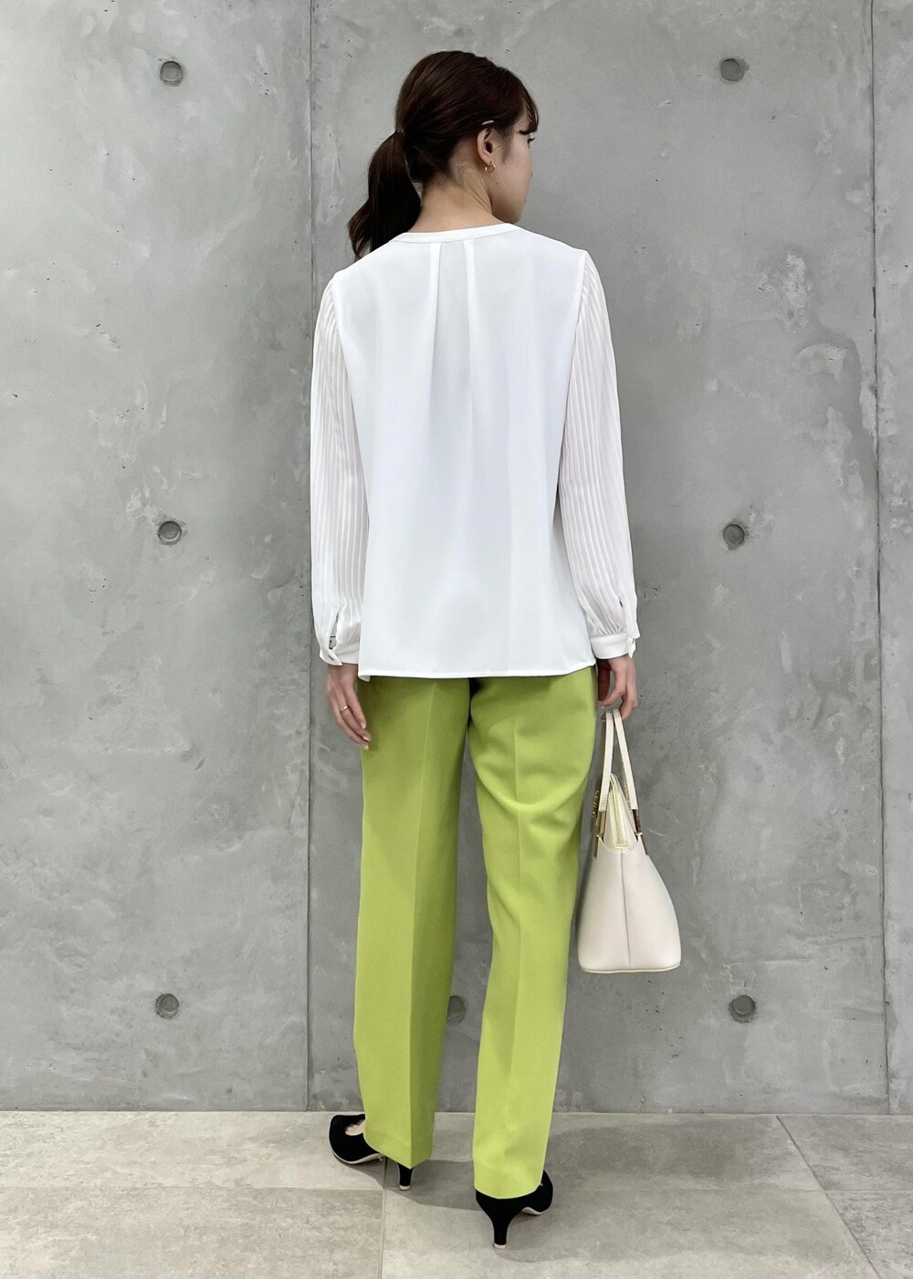ホワイト系のシャツ/ブラウス、ホワイト系のショルダーバッグ、グリーン系のスラックスを着用したレディースの春コーディネートの3枚目の写真