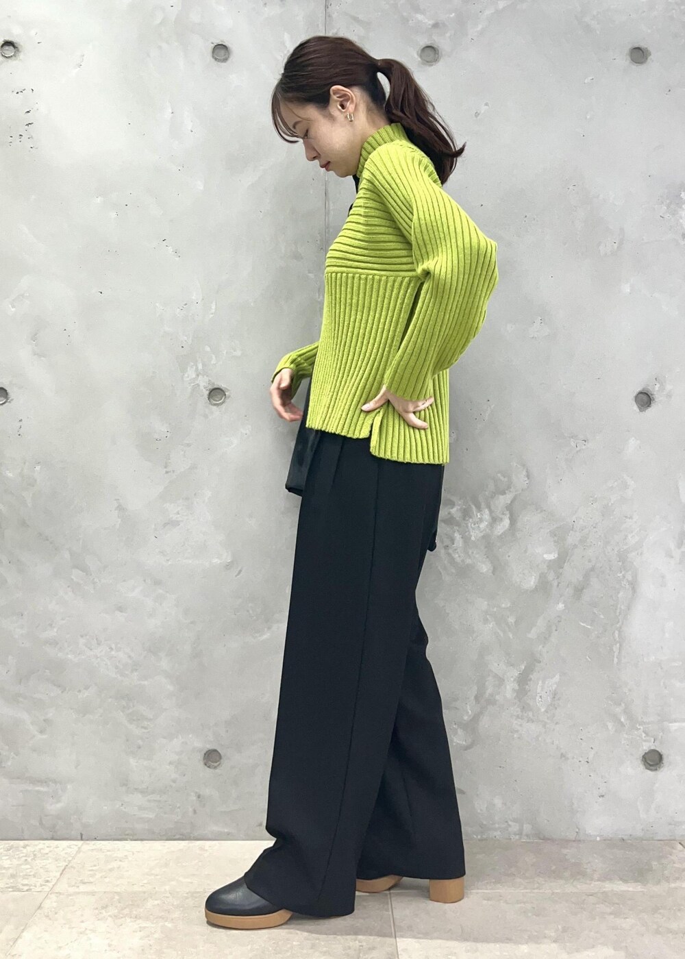 グリーン系のニット/セーター、ブラック系のショルダーバッグ、ブラック系のその他パンツを着用したレディースの秋コーディネートの2枚目の写真