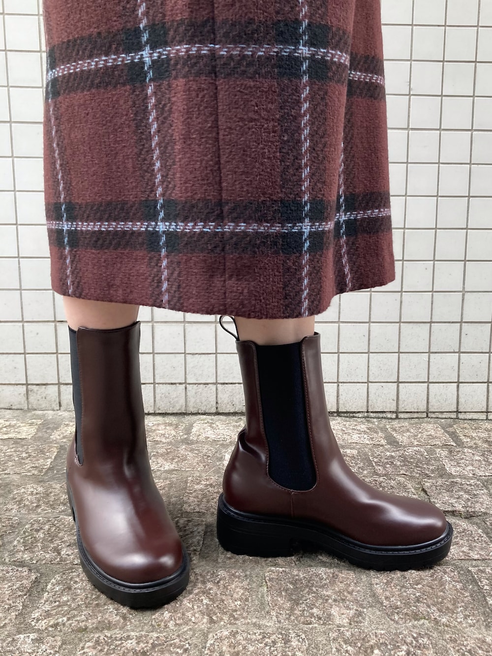 ベージュ系のニット/セーター、ゴールド系のトートバッグ、ブラウン系のブーツを着用したレディースの秋コーディネートの5枚目の写真