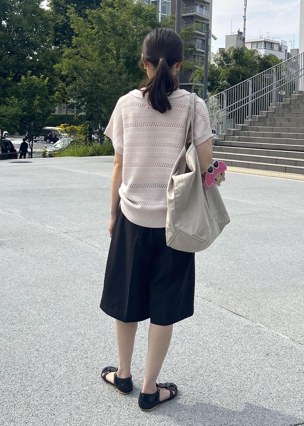 ピンク系のニット/セーター、ブラック系のその他パンツ、ピンク系のショルダーバッグを着用したレディースの夏コーディネートの3枚目の写真