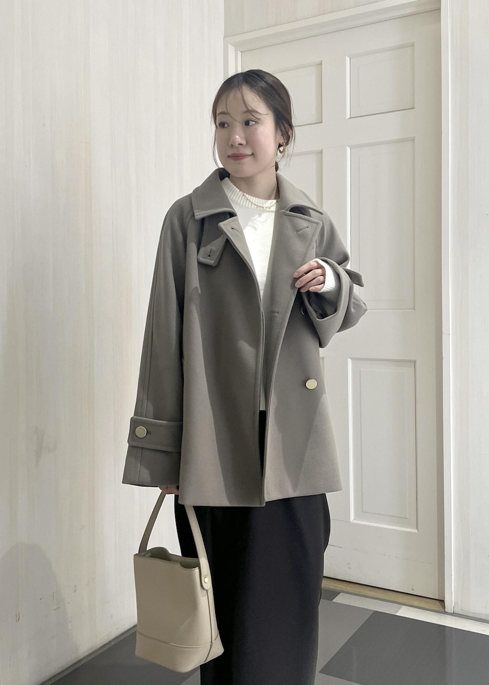 ホワイト系のニット/セーター、ブラウン系のその他アウター、ベージュ系のショルダーバッグを着用したレディースの冬コーディネートの5枚目の写真