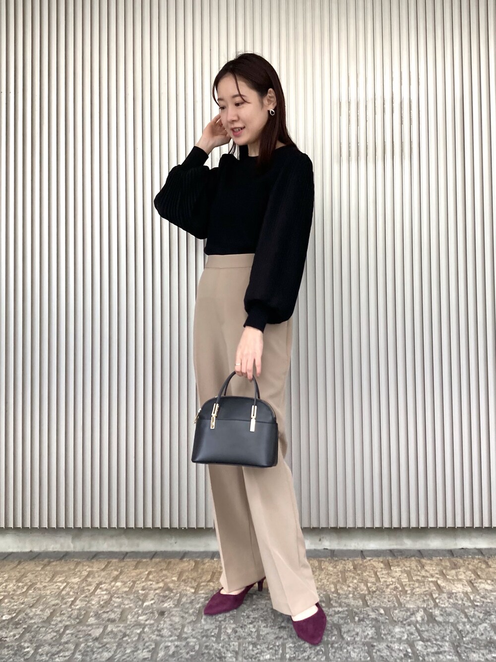 ブラック系のニット/セーター、ベージュ系のステンカラーコート、ブラック系のショルダーバッグを着用したレディースの秋コーディネートの4枚目の写真
