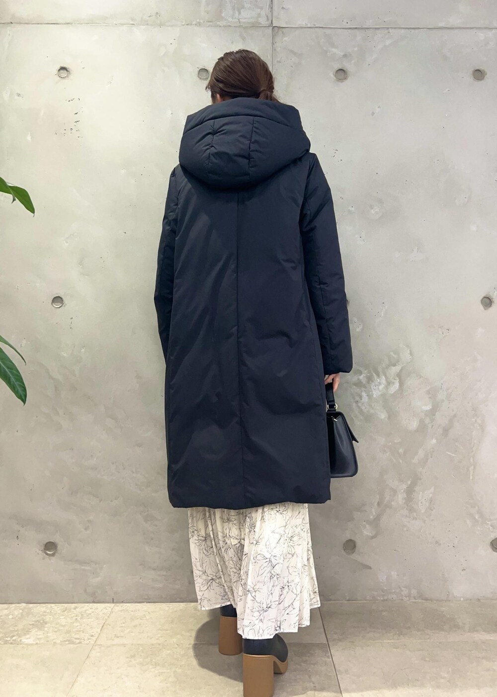 ホワイト系のスカート、グレー系のニット/セーター、ブラック系のショルダーバッグを着用したレディースの冬コーディネートの3枚目の写真