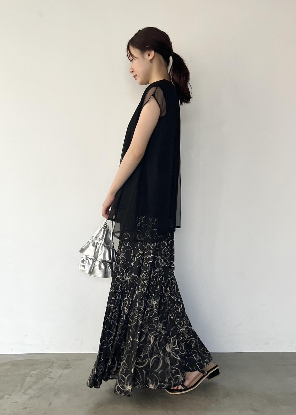 ブラック系のサンダル、ブラック系のTシャツ/カットソー、ブラック系のスカートを着用したレディースの夏コーディネートの2枚目の写真