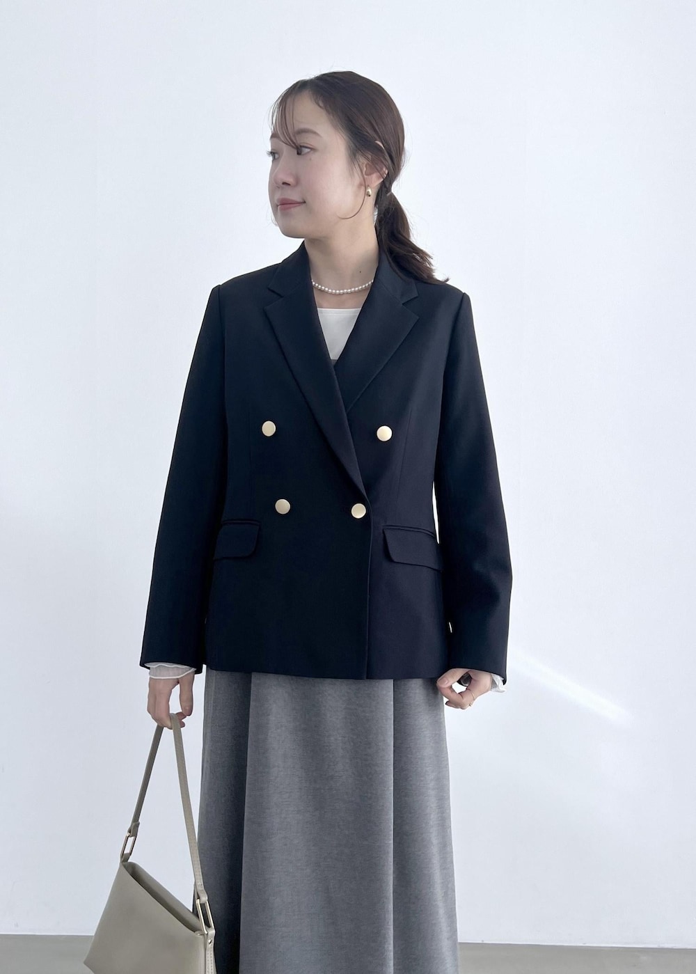 ホワイト系のTシャツ/カットソー、グレー系のワンピース、ベージュ系のショルダーバッグを着用したレディースの冬コーディネートの4枚目の写真