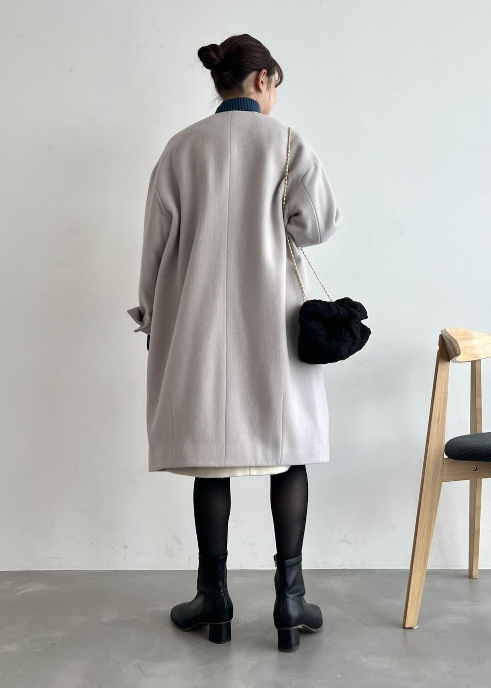 ブルー系のニット/セーター、ブラック系のブーツ、グレー系のノーカラーコートを着用したレディースの冬コーディネートの3枚目の写真