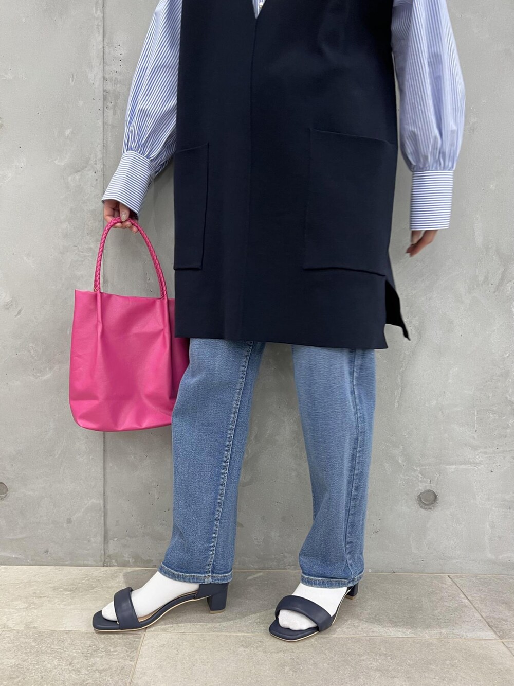 ブルー系のベスト、ブルー系のサンダル、ピンク系のトートバッグを着用したレディースの春コーディネートの5枚目の写真