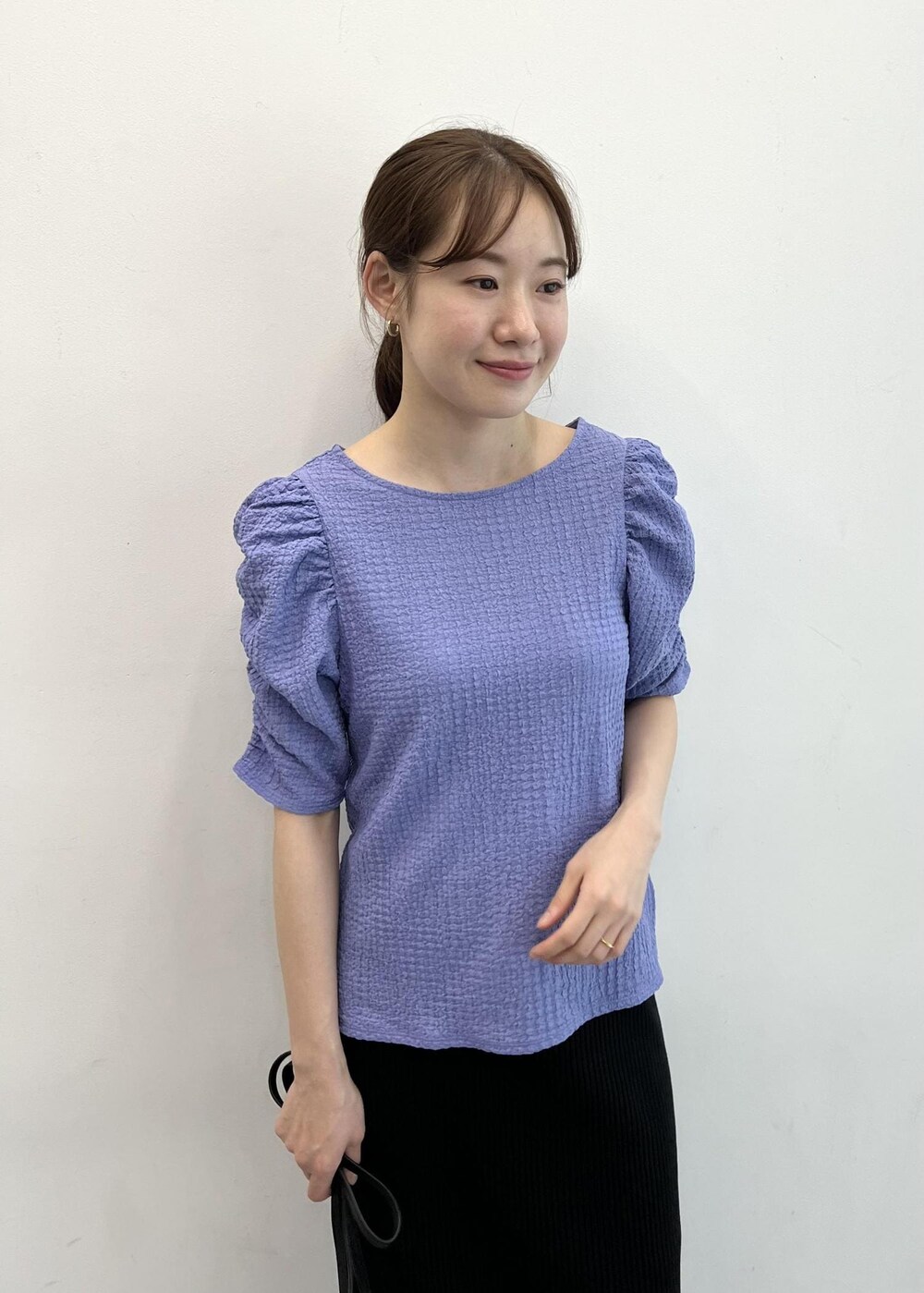 ブラック系のショルダーバッグ、ブルー系のTシャツ/カットソー、ブラック系のスカートを着用したレディースの夏コーディネートの6枚目の写真