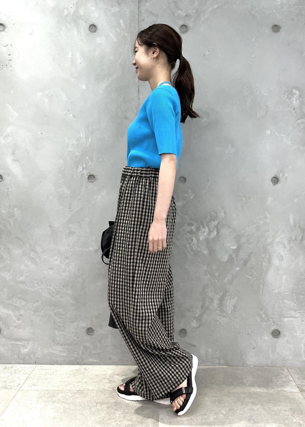 グレー系のテーラードジャケット、ブラウン系のその他パンツ、ブルー系のニット/セーターを着用したレディースの春コーディネートの2枚目の写真