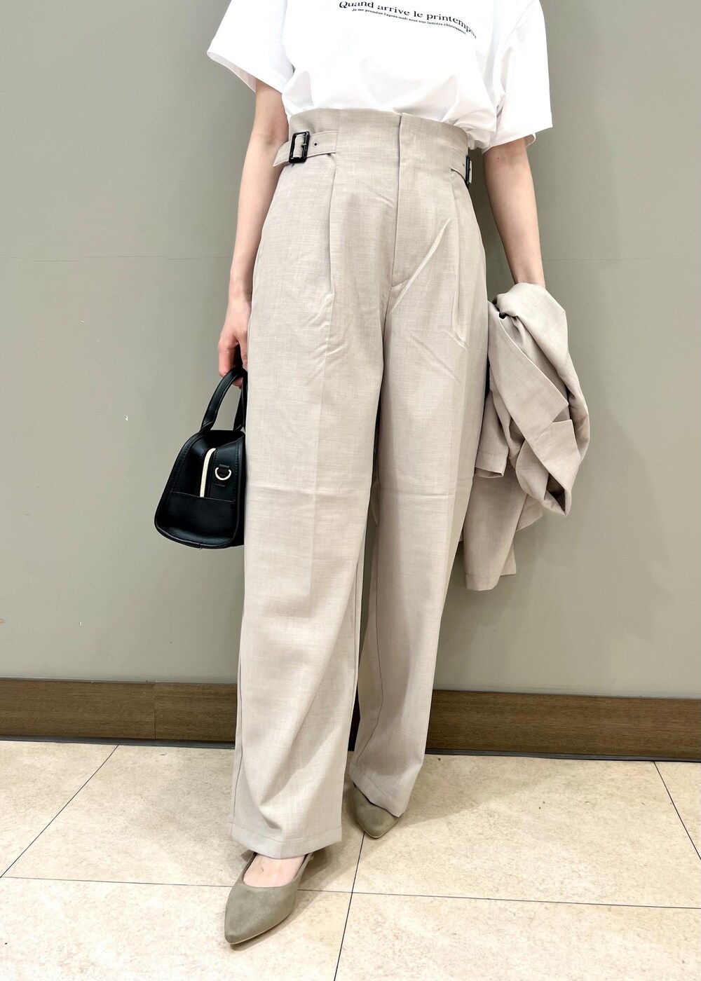 ブラック系のボストンバッグ、ベージュ系のテーラードジャケット、ホワイト系のTシャツ/カットソーを着用したレディースの夏コーディネートの4枚目の写真