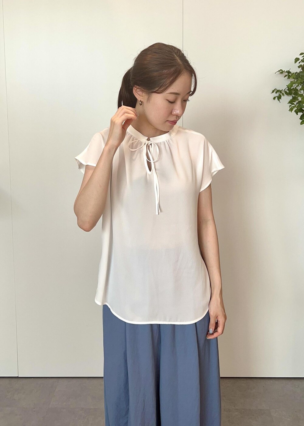 シルバー系のトートバッグ、ホワイト系のサンダル、ブルー系のその他パンツを着用したレディースの夏コーディネートの3枚目の写真