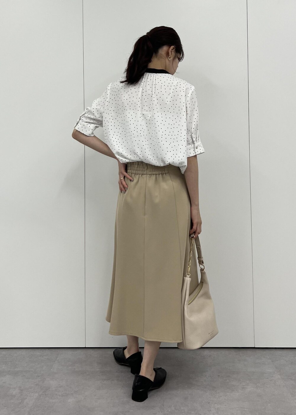 ベージュ系のショルダーバッグ、ベージュ系のスカート、ホワイト系のシャツ/ブラウスを着用したレディースの夏コーディネートの3枚目の写真