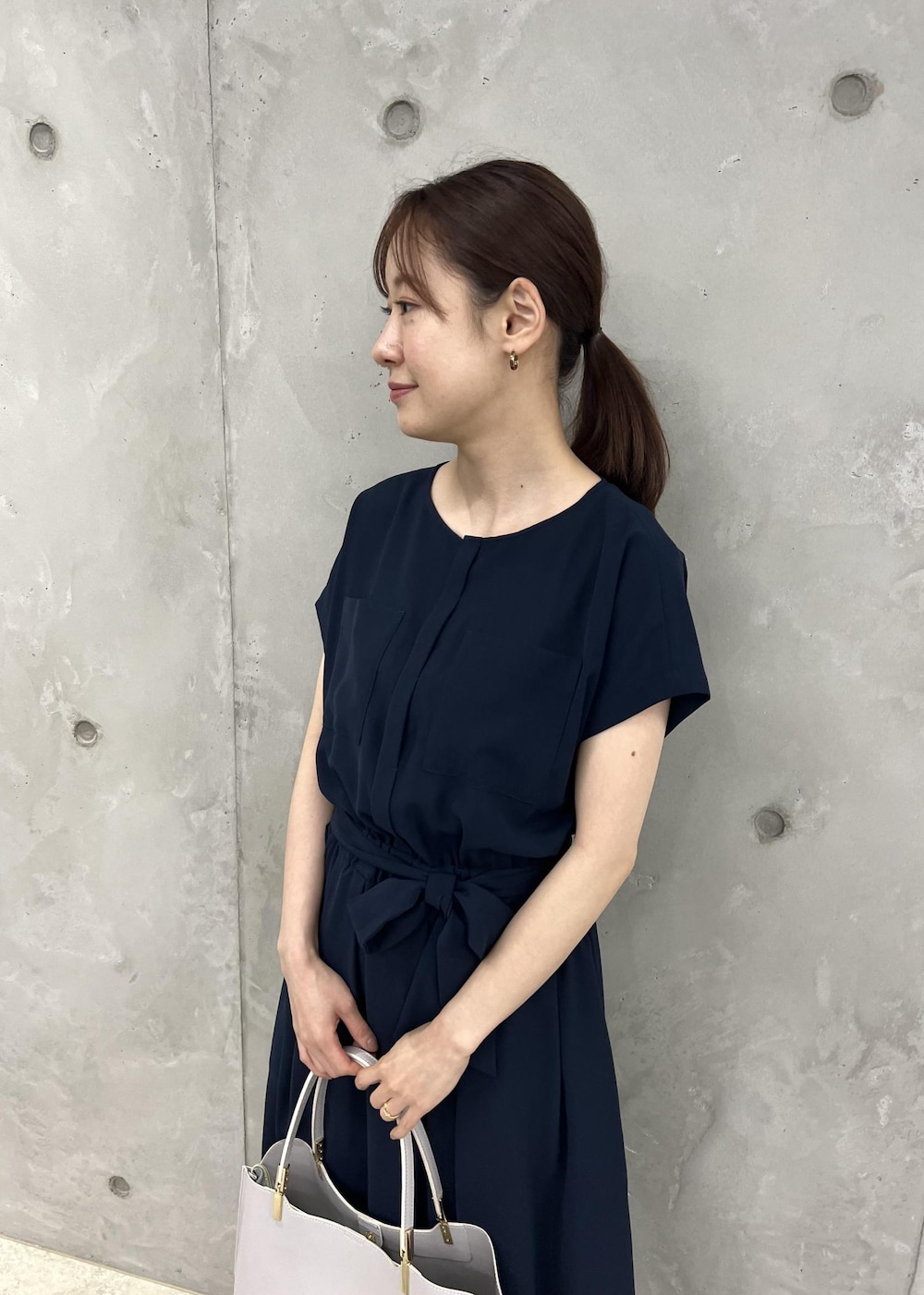 シルバー系のサンダル、ブルー系のワンピース、グレー系のトートバッグを着用したレディースの夏コーディネートの4枚目の写真