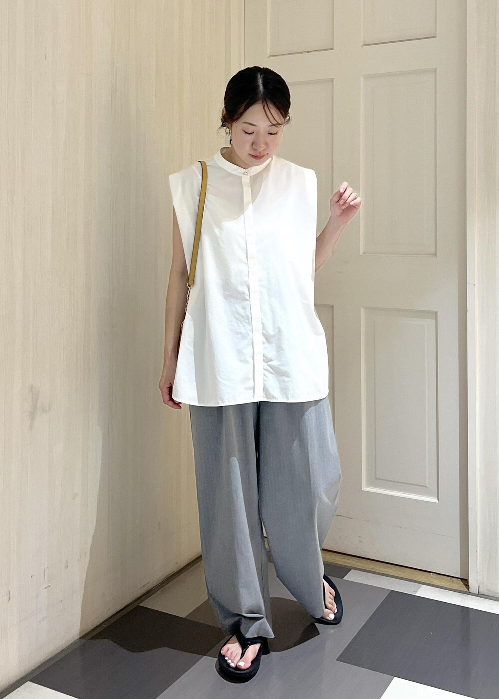 ホワイト系のシャツ/ブラウス、グレー系のその他パンツ、ブラック系のサンダルを着用したレディースの夏コーディネートの2枚目の写真