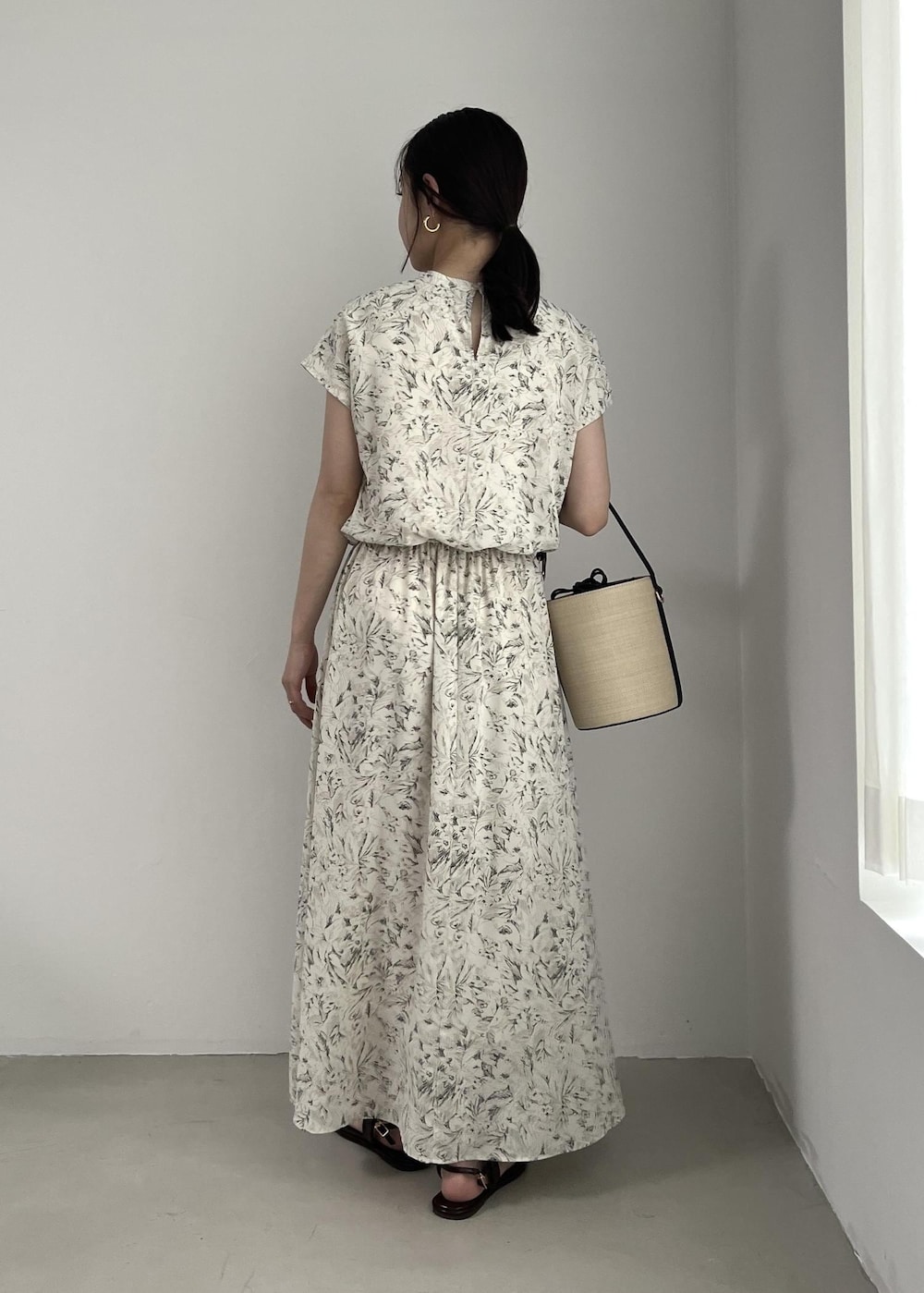 ホワイト系のブルゾン、ブラック系のサンダル、ホワイト系のワンピースを着用したレディースの春コーディネートの8枚目の写真