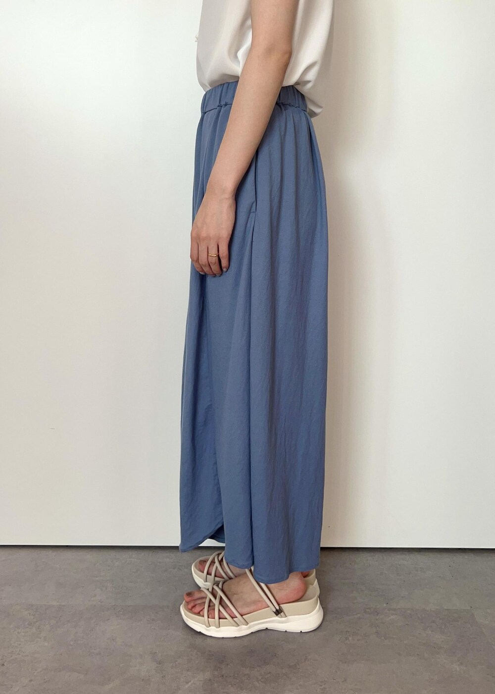 シルバー系のトートバッグ、ホワイト系のサンダル、ブルー系のその他パンツを着用したレディースの夏コーディネートの6枚目の写真