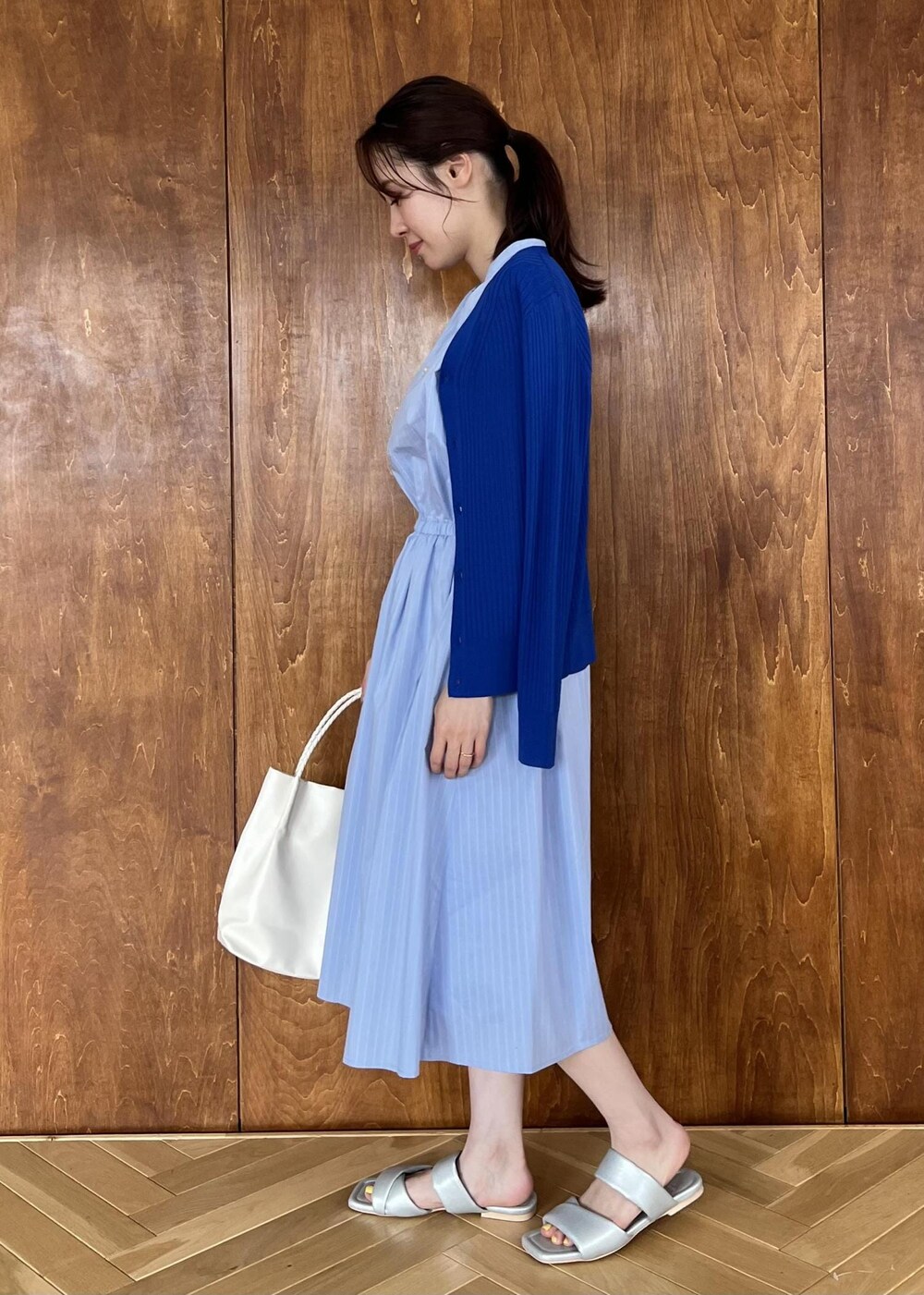 シルバー系のサンダル、ブルー系のカーディガン/ボレロ、ホワイト系のトートバッグを着用したレディースの夏コーディネートの2枚目の写真