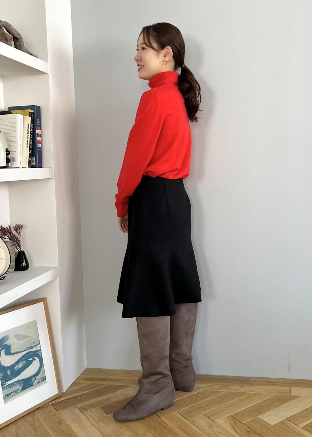 ブラック系のスカート、レッド系のニット/セーター、ベージュ系のブーツを着用したレディースの冬コーディネートの2枚目の写真
