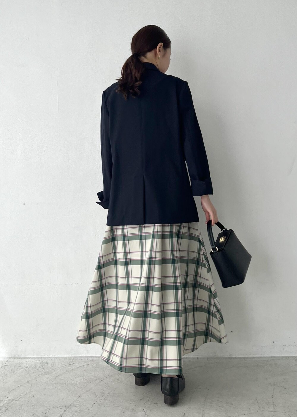 ブルー系のテーラードジャケット、グリーン系のスカート、グリーン系のニット/セーターを着用したレディースの春コーディネートの6枚目の写真