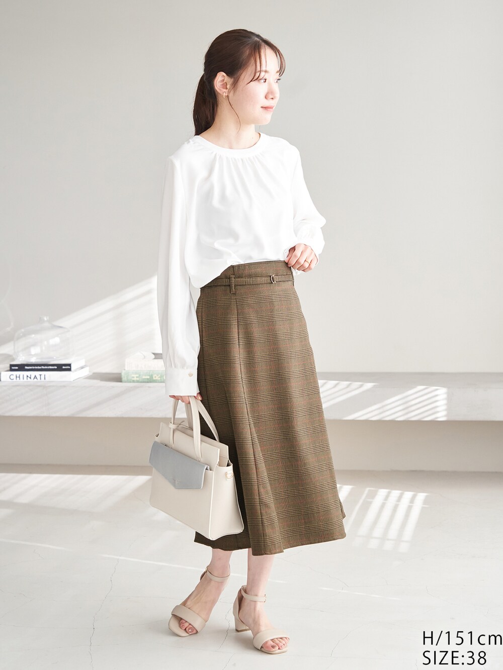 ホワイト系のシャツ/ブラウス、ブラウン系のスカート、ベージュ系のサンダルを着用したレディースの冬コーディネートの2枚目の写真