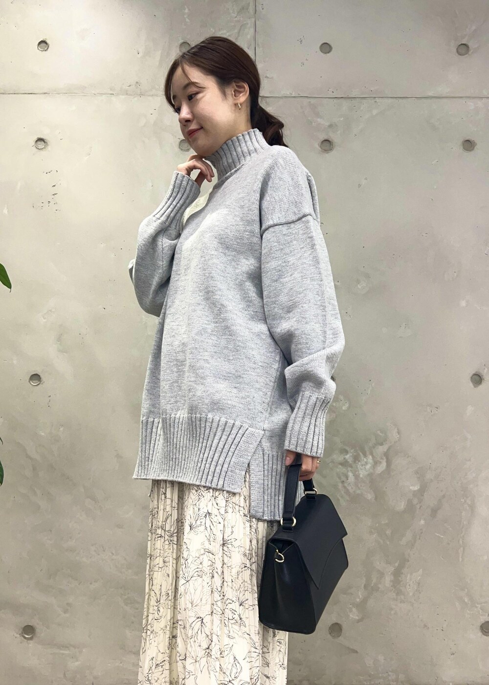 ホワイト系のスカート、グレー系のニット/セーター、ブラック系のショルダーバッグを着用したレディースの冬コーディネートの7枚目の写真