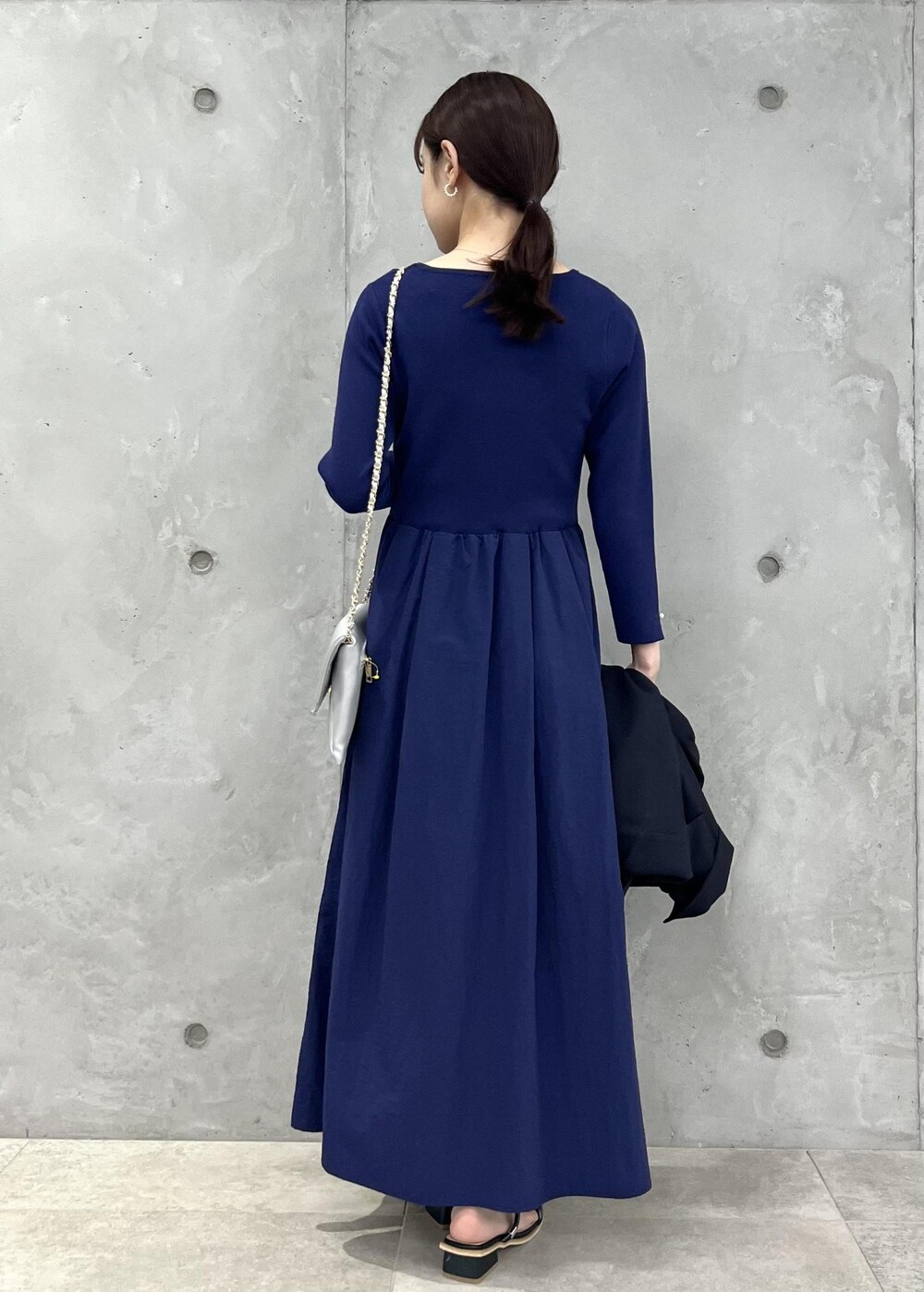 シルバー系のショルダーバッグ、ブラック系のサンダル、ブルー系のテーラードジャケットを着用したレディースの夏コーディネートの2枚目の写真