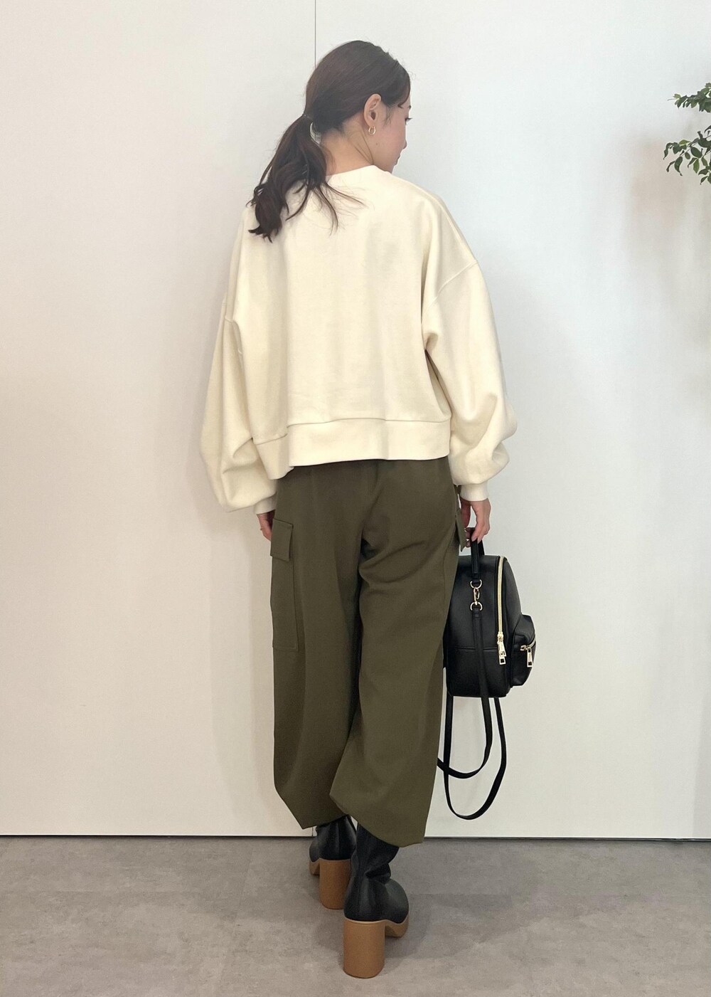 ブラック系のバックパック/リュック、ブラック系のブーツ、ホワイト系のスウェットを着用したレディースの秋コーディネートの3枚目の写真
