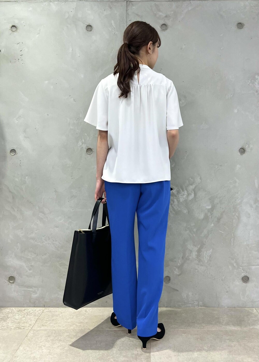 ブラック系のパンプス、グレー系のシャツ/ブラウス、ブラック系のトートバッグを着用したレディースの夏コーディネートの3枚目の写真