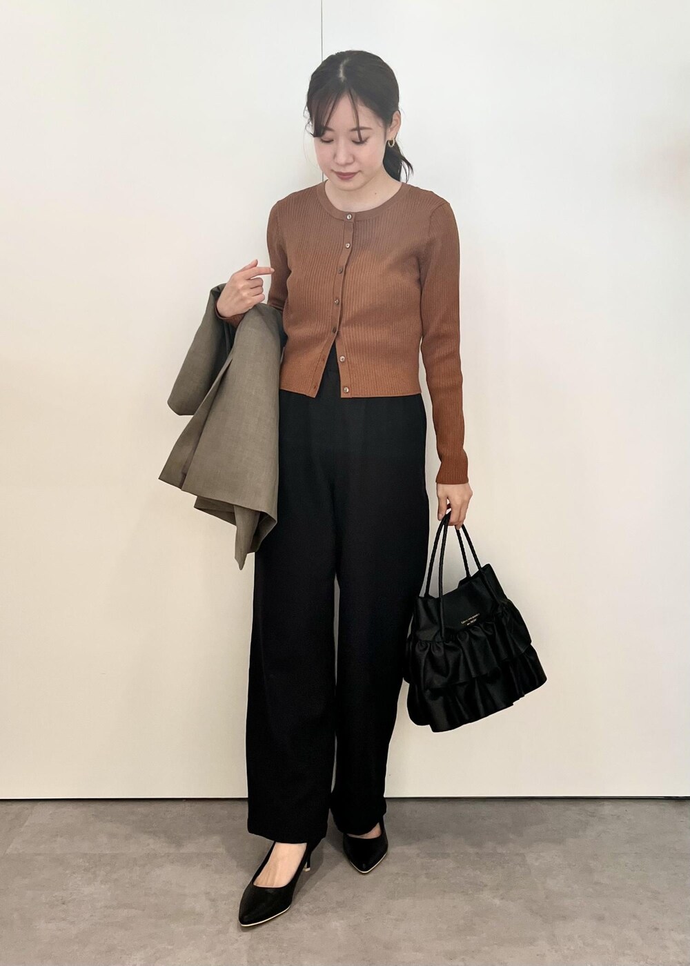 ブラック系のトートバッグ、ブラック系のその他パンツ、ブラウン系のカーディガン/ボレロを着用したレディースの秋コーディネートの5枚目の写真