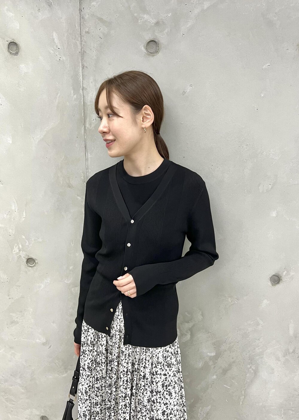 ブラック系のカーディガン/ボレロ、ホワイト系のスカート、ブラック系のニット/セーターを着用したレディースの春コーディネートの6枚目の写真