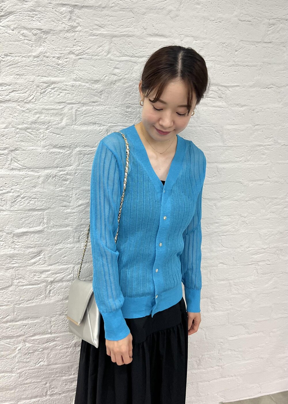 シルバー系のショルダーバッグ、シルバー系のサンダル、ブルー系のカーディガン/ボレロを着用したレディースの秋コーディネートの4枚目の写真