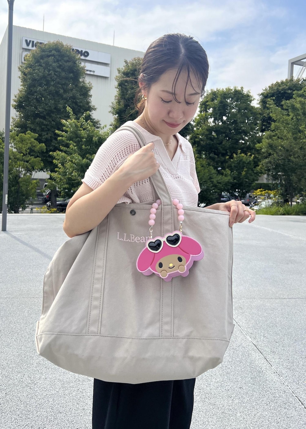 ピンク系のニット/セーター、ブラック系のその他パンツ、ピンク系のショルダーバッグを着用したレディースの夏コーディネートの4枚目の写真