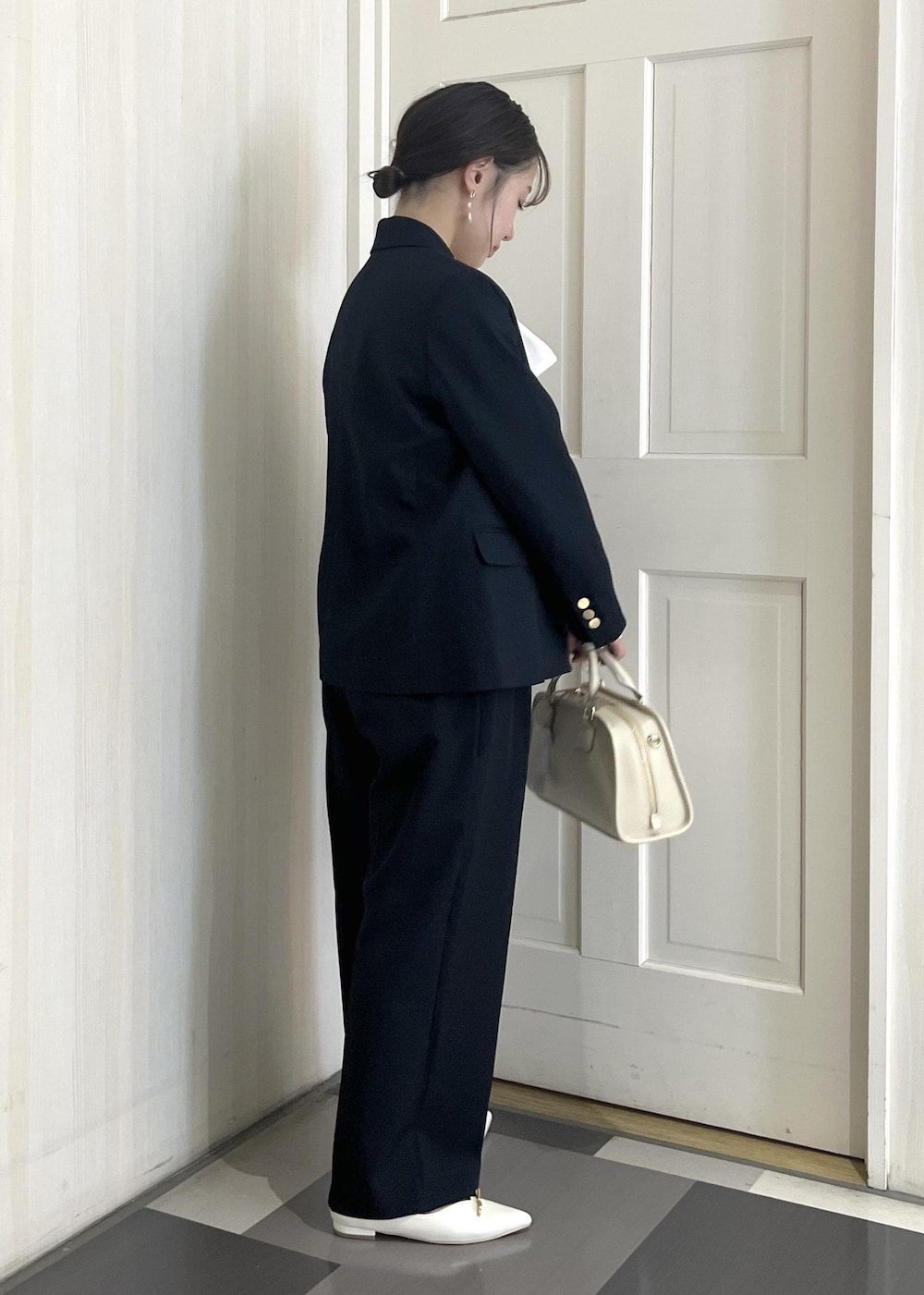 ホワイト系のボストンバッグ、ホワイト系のパンプス、ブルー系のその他パンツを着用したレディースの冬コーディネートの4枚目の写真