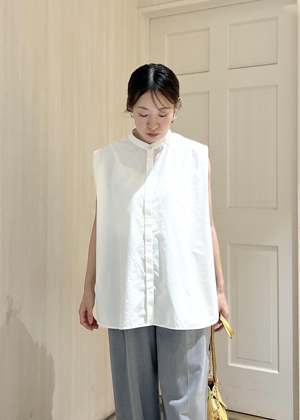 ホワイト系のシャツ/ブラウス、グレー系のその他パンツ、ブラック系のサンダルを着用したレディースの夏コーディネートの6枚目の写真