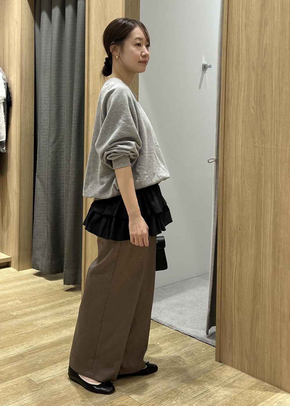 ブラック系のショルダーバッグ、ブラック系のキャミソール、グレー系のスウェットを着用したレディースの秋コーディネートの5枚目の写真