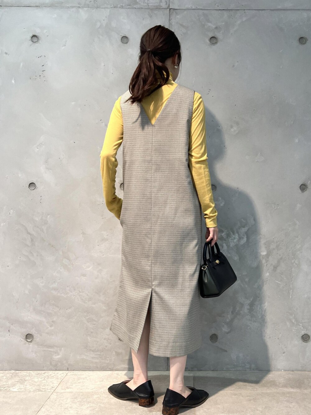 グリーン系のジャンパースカート、ブラック系のショルダーバッグ、ブラック系のその他シューズを着用したレディースの夏コーディネートの3枚目の写真