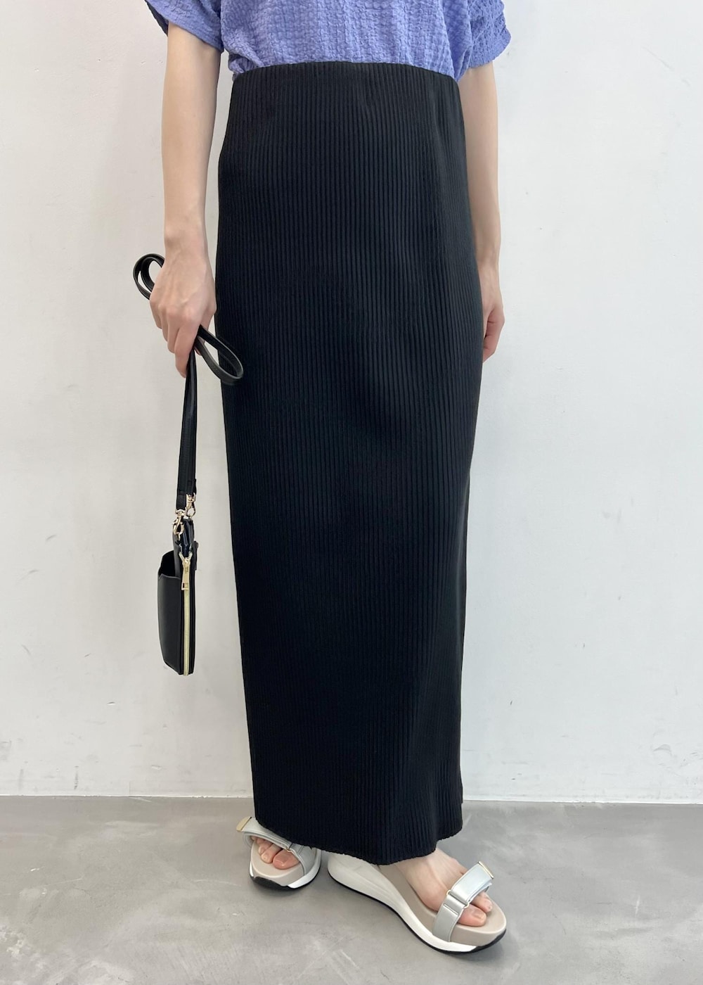 ブラック系のショルダーバッグ、ブルー系のTシャツ/カットソー、ブラック系のスカートを着用したレディースの夏コーディネートの4枚目の写真