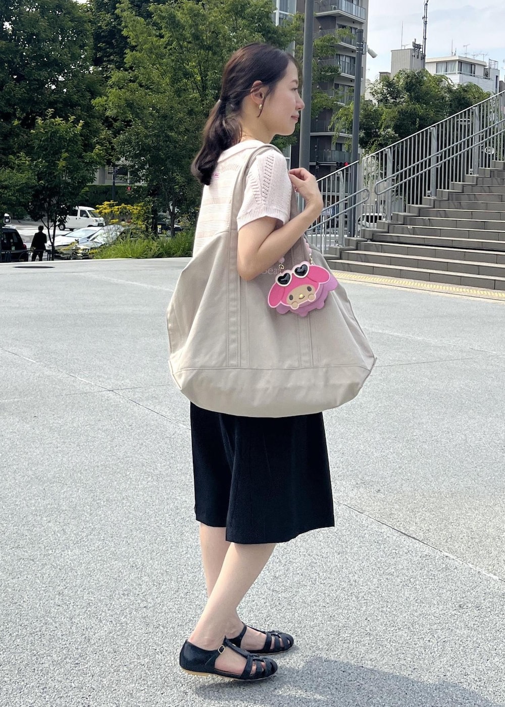 ピンク系のニット/セーター、ブラック系のその他パンツ、ピンク系のショルダーバッグを着用したレディースの夏コーディネートの2枚目の写真