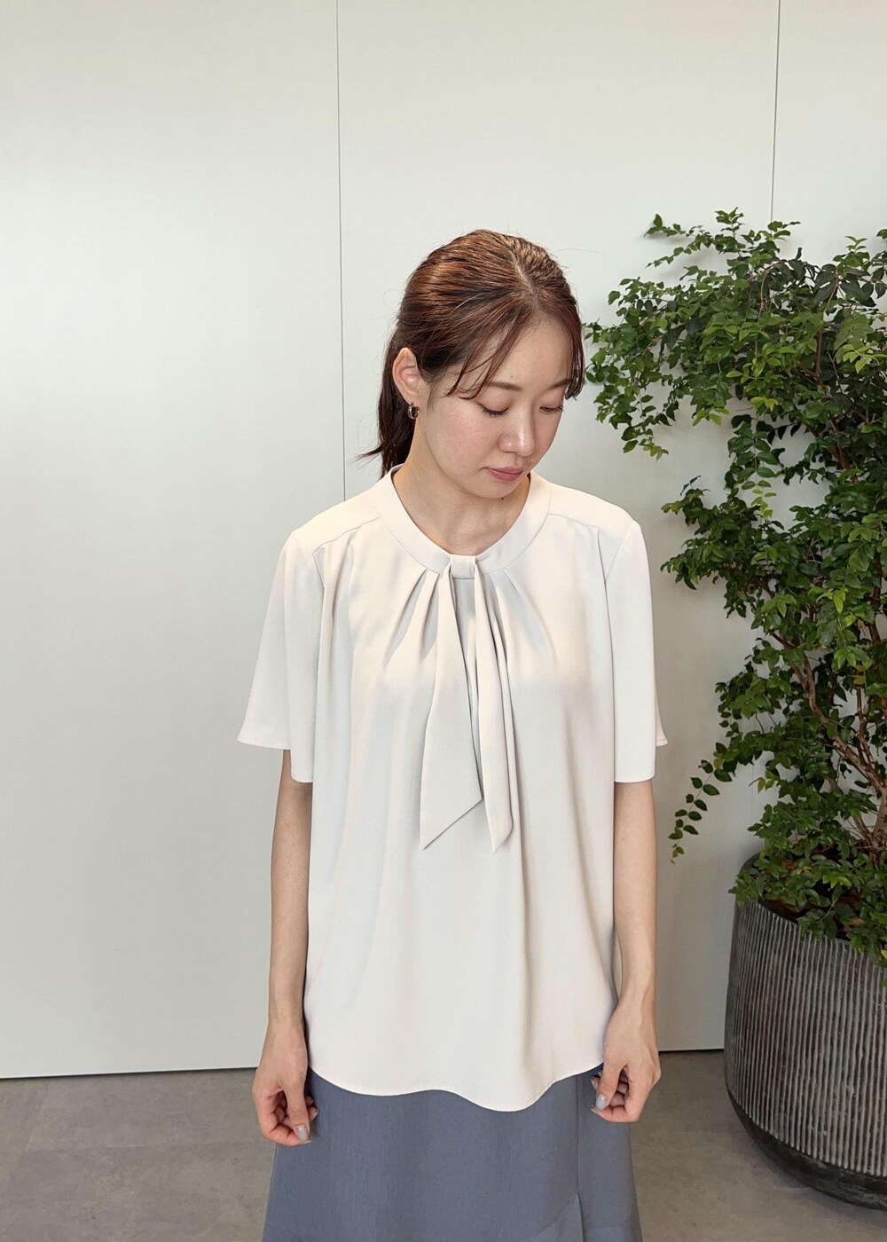 グレー系のシャツ/ブラウス、ブルー系のパンプス、シルバー系のショルダーバッグを着用したレディースの夏コーディネートの5枚目の写真