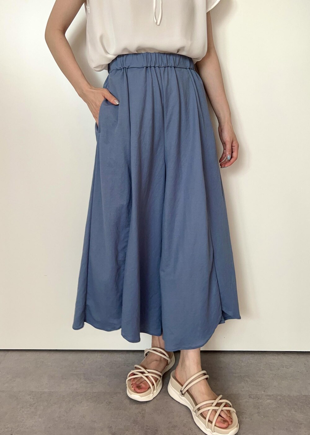 シルバー系のトートバッグ、ホワイト系のサンダル、ブルー系のその他パンツを着用したレディースの夏コーディネートの5枚目の写真