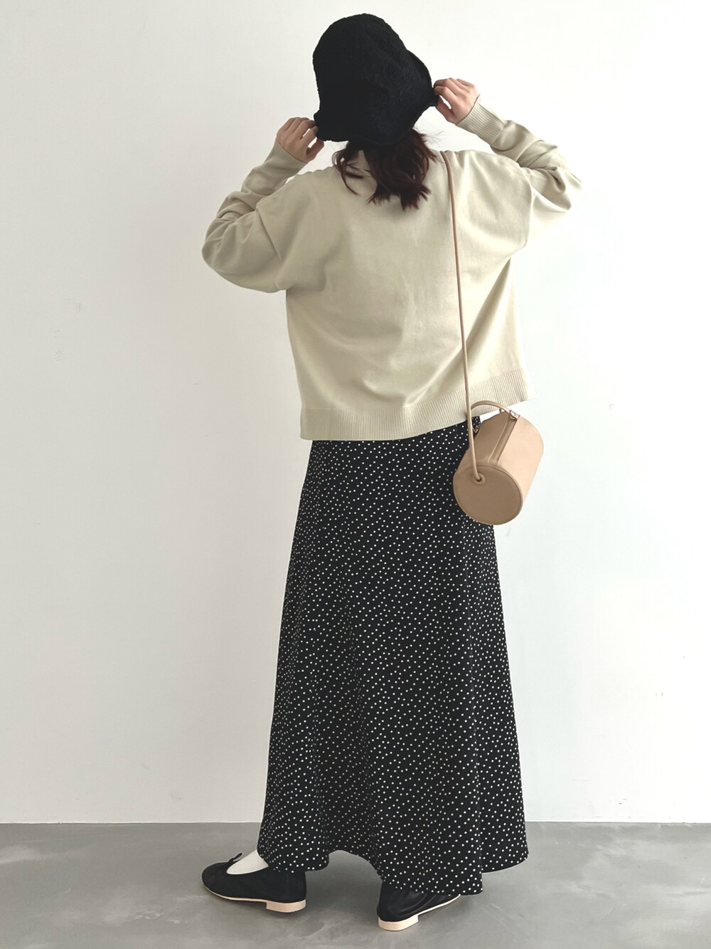 ベージュ系のニット/セーター、ブラック系のスカート、ブラック系のバレエシューズを着用したレディースの春コーディネートの4枚目の写真