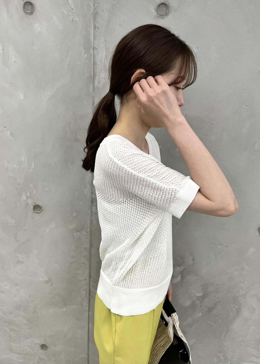 ブラック系のサンダル、イエロー系のスラックス、ブラック系のショルダーバッグを着用したレディースの夏コーディネートの5枚目の写真