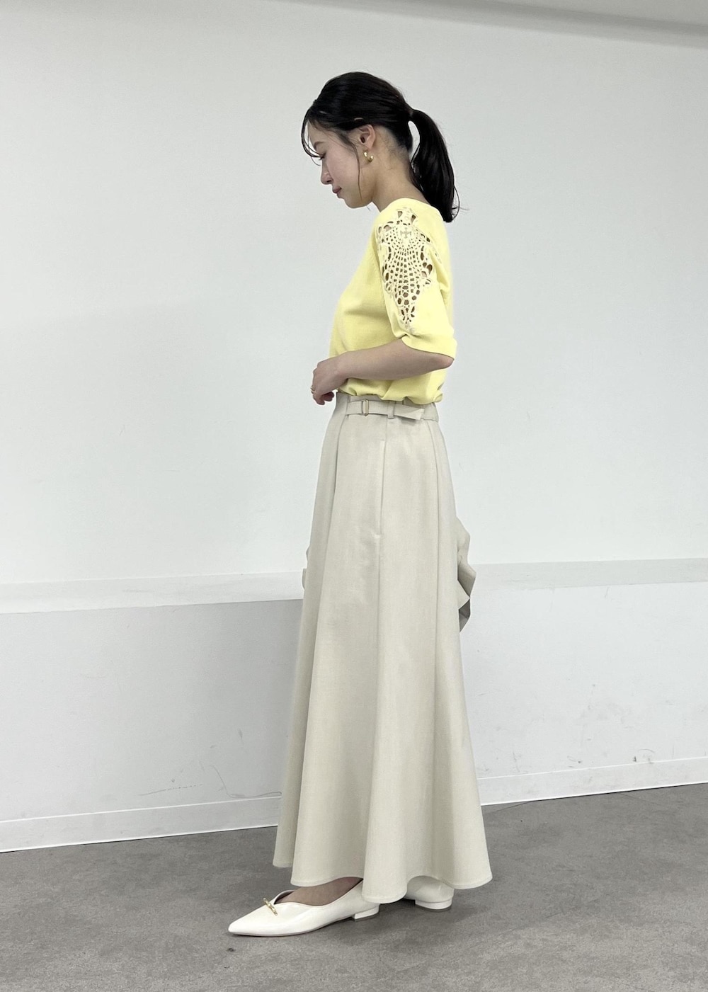 ホワイト系のパンプス、ベージュ系のテーラードジャケット、ベージュ系のスカートを着用したレディースの春コーディネートの5枚目の写真